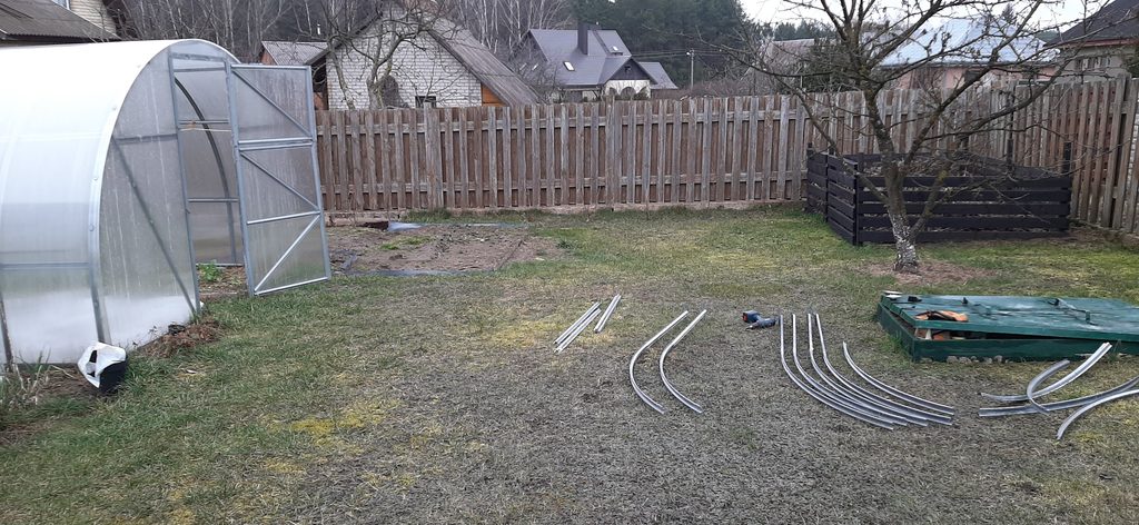 Polycarbonate greenhouse extension frame parts laid out on the ground