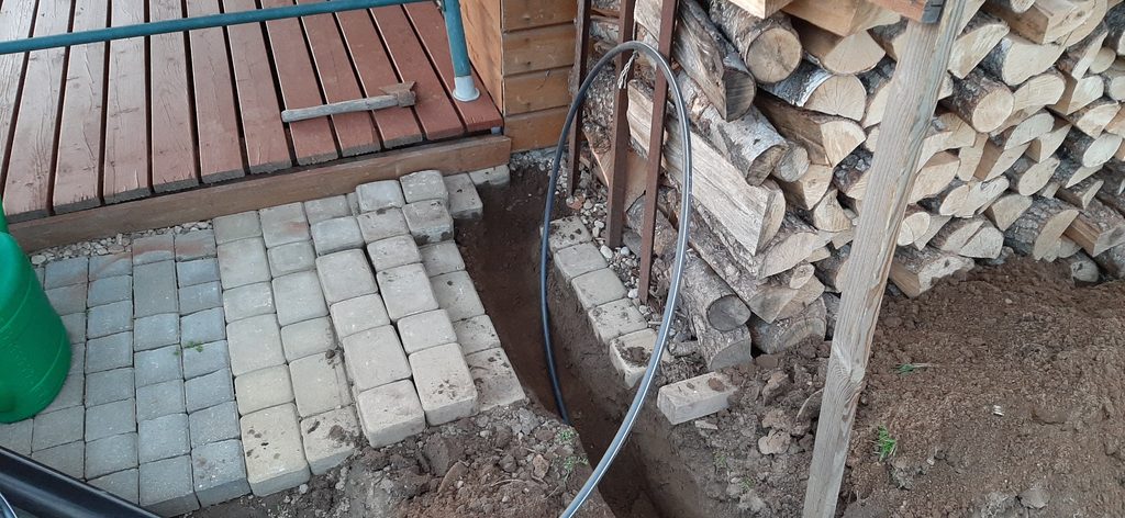 Underground power cable trench beside garage